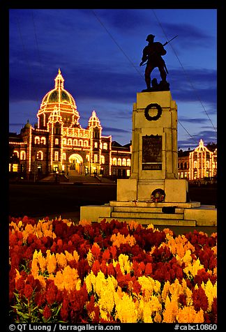 Flowers, memorial statue and illuminated parliament building at night. Victoria, British Columbia, Canada (color)