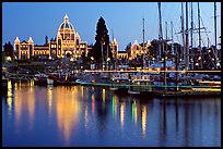 Boats in inner harbor with a trail of lights and parliament building lights. Victoria, British Columbia, Canada (color)