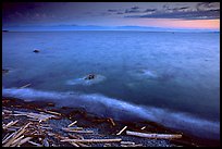 Beach with driftwood, and Olympic Mountains across the Juan de Fuca Strait. Victoria, British Columbia, Canada (color)