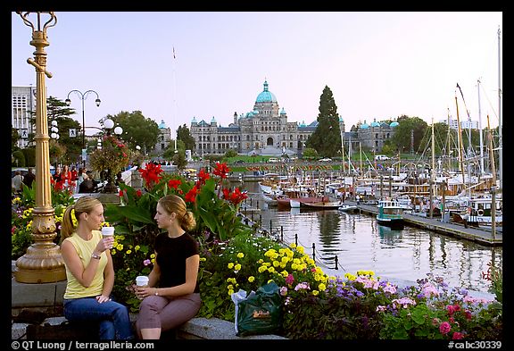 Women drinking coffee at the Inner Harbour, sunset. Victoria, British Columbia, Canada (color)