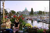 Women drinking coffee at the Inner Harbour, sunset. Victoria, British Columbia, Canada