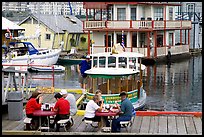 People eating fish and chips on deck,  Fisherman's wharf. Victoria, British Columbia, Canada
