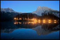Lighted cabins and mountains reflected in Emerald Lake at night. Yoho National Park, Canadian Rockies, British Columbia, Canada