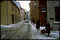 Residents pulling a sled with a child in a street, Quebec City. Quebec, Canada ( color)