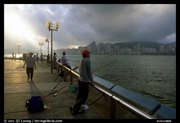 Fishing on the waterfront promenade, sunrise. Hong-Kong, China