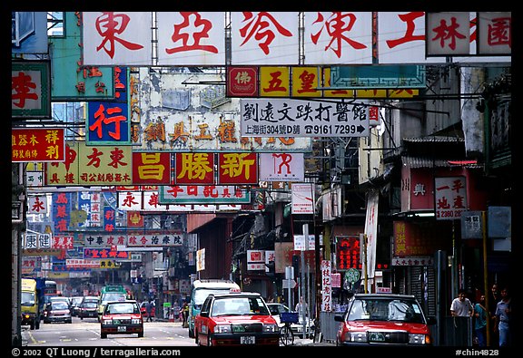 Taxicabs in a street filled up with signs in Chinese, Kowloon. Hong-Kong, China