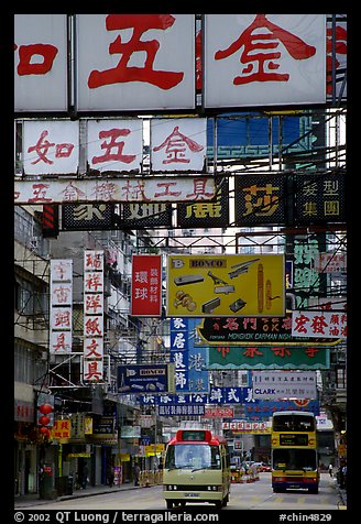 Busses in a street filled up with signs in Chinese, Kowloon. Hong-Kong, China