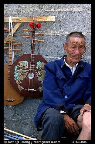 Man selling musical instruments. Shaping, Yunnan, China