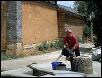 Bai woman fills up a water bucket at the well. Shaping, Yunnan, China ( color)