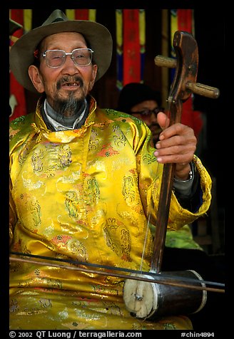 Elderly musician playing the traditional two-stringed Ehru. Baisha, Yunnan, China