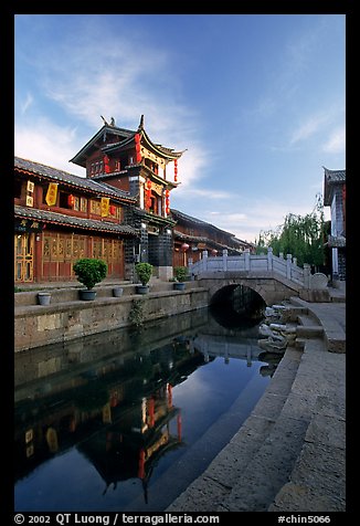 Kegong tower (memorial archway of imperial exam) reflected in canal, sunrise. Lijiang, Yunnan, China (color)