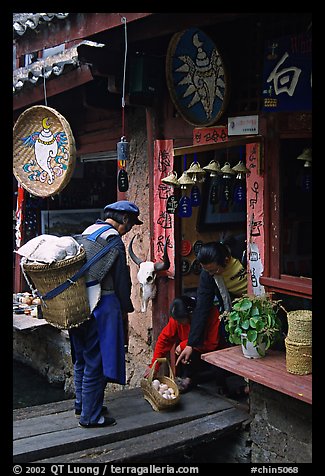 Naxi woman offers eggs for sale to local residents. Lijiang, Yunnan, China