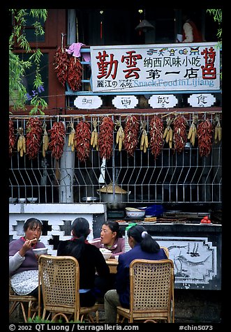 Women eat outside the Snack Food in Lijiang restaurant. Lijiang, Yunnan, China
