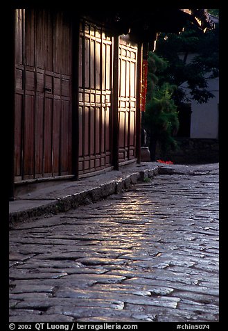 Cobblestone street and wooden doors at sunrise. Lijiang, Yunnan, China (color)