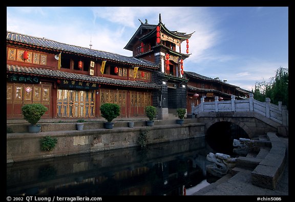 Kegong tower (memorial archway of imperial exam) reflected in canal, sunrise. Lijiang, Yunnan, China