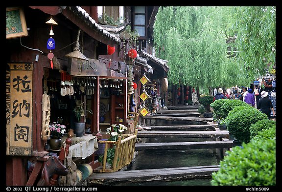Bridges leading to restaurants and residences across the canal. Lijiang, Yunnan, China