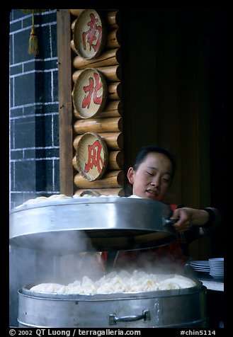 Woman baking dumplings. Lijiang, Yunnan, China