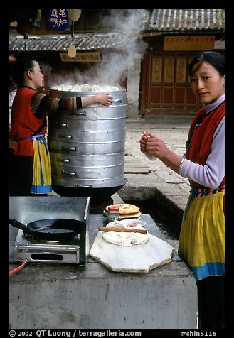 Naxi Woman preparing the baba flatbreat. Lijiang, Yunnan, China (color)