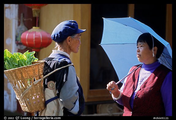 Two women conversing in the street. Lijiang, Yunnan, China (color)