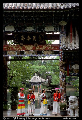 Women in Naxi dress standing in an archway. Lijiang, Yunnan, China