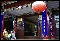 Women sit ouside  the Wufeng Lou (Five Phoenix Hall). Lijiang, Yunnan, China ( color)