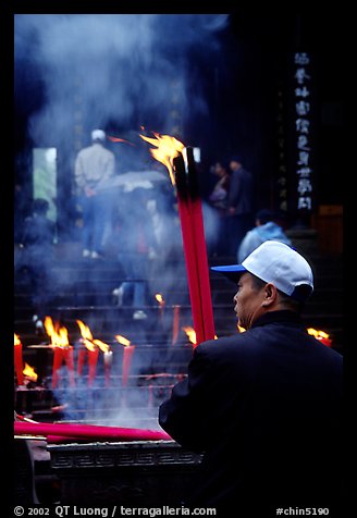 Pilgrim offering big incense stick. Emei Shan, Sichuan, China (color)
