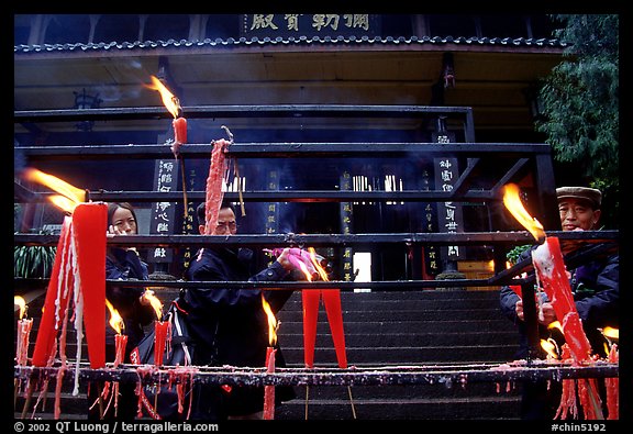 Pilgrims lighting incense sticks with Wannian Si temple in the background. Emei Shan, Sichuan, China (color)
