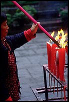 Woman Pilgrim lighting a large incense stick, Wannian Si. Emei Shan, Sichuan, China