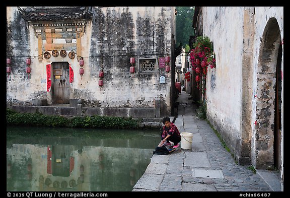 Woman washes laundry in Moon Pond. Hongcun Village, Anhui, China (color)