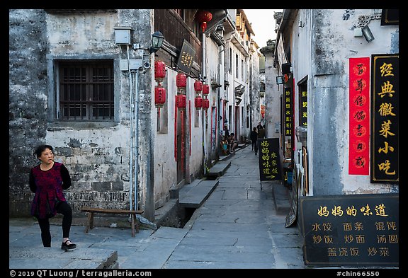Woman standing next to main street. Xidi Village, Anhui, China