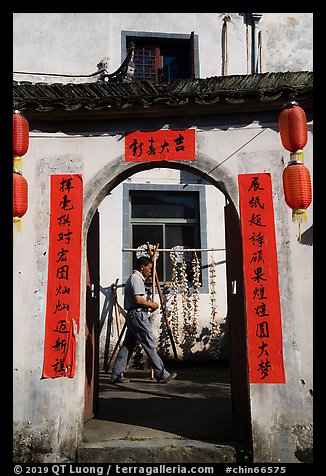 Man with garlic braids hung to dry. Xidi Village, Anhui, China