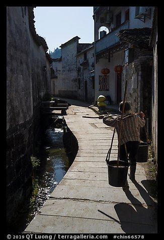 Woman carrying buckets. Xidi Village, Anhui, China