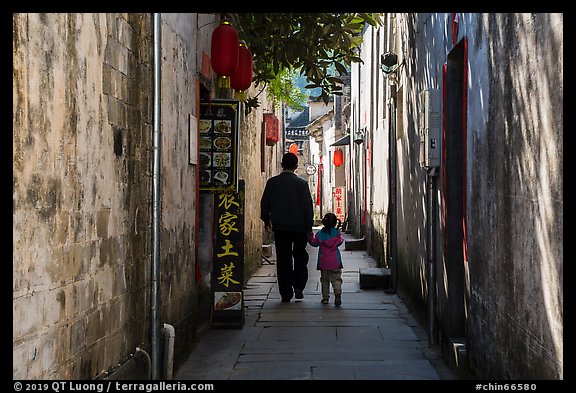 Father and daughter walking in alley. Xidi Village, Anhui, China