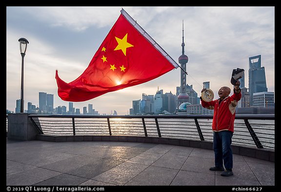 Man saluting Chinese flag and skyline, the Bund. Shanghai, China (color)