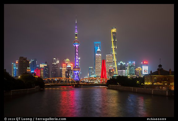 Garden Bridge, Peoples Memorial and city skyline at night. Shanghai, China (color)