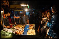 Sampling snacks at Shilin Night Market. Taipei, Taiwan (color)