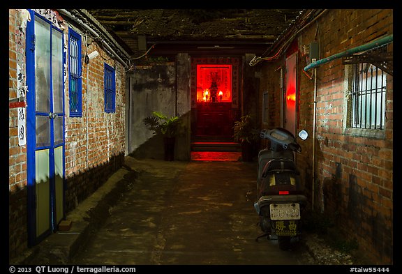 Alley at night with temple altar glowing red. Lukang, Taiwan