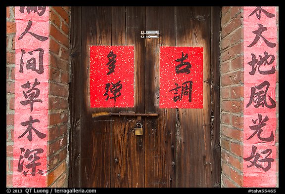 Wooden door and brick wall with Chinese writing. Lukang, Taiwan