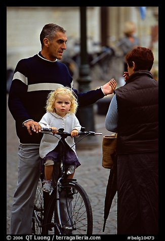 Blond little girl sitting on bicycle. Bruges, Belgium (color)