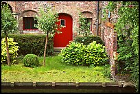 Small garden and brick house by the canal. Bruges, Belgium ( color)