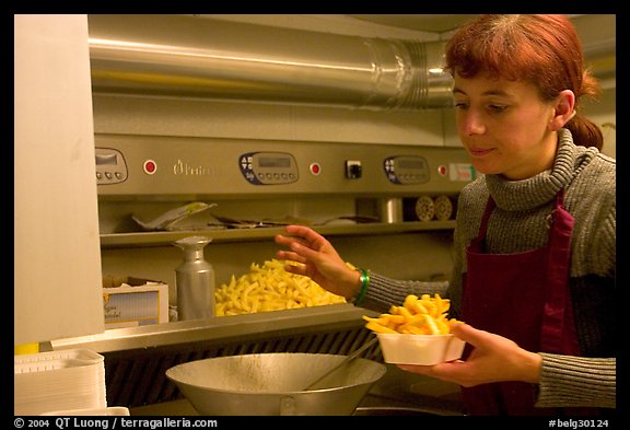 Woman preparing fries in a booth. Bruges, Belgium