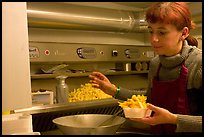 Woman preparing fries in a booth. Bruges, Belgium