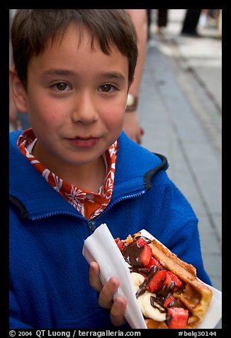 Boy eating a Belgian waffle. Brussels, Belgium (color)