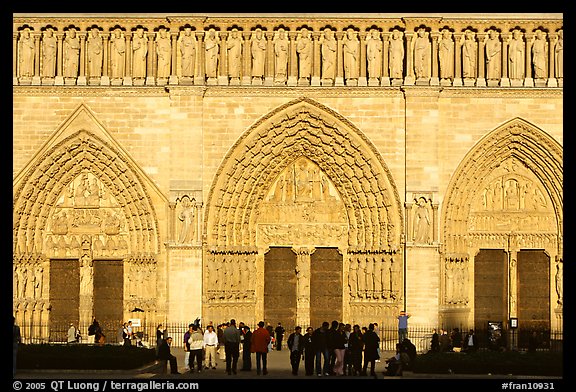 People standing in front of gates of Notre Dame Cathedral, late afternoon. Paris, France (color)
