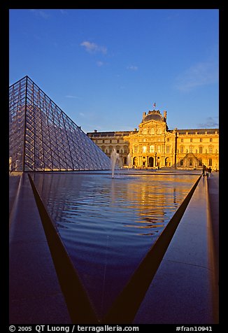 Pyramid and triangular basin in the Louvre, sunset. Paris, France