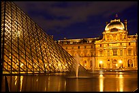 Pyramid, basin, and Louvre at night. Paris, France