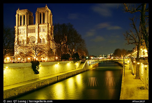 Facade of Notre Dame and Seine river at night. Paris, France