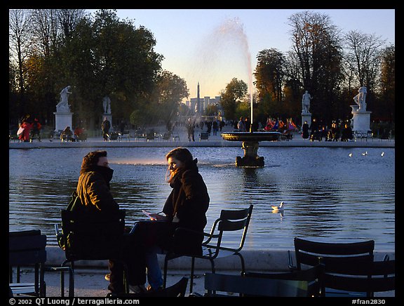 Couple sitting by basin in Tuileries Gardens. Paris, France