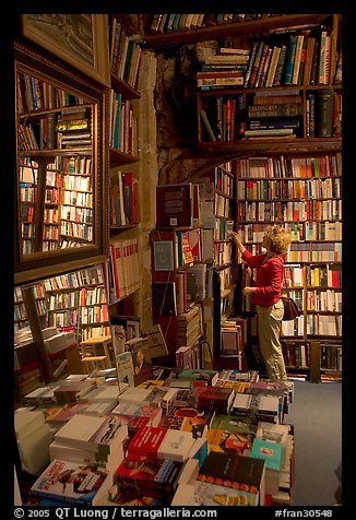 Picking-up a book in Shakespeare and Co bookstore. Quartier Latin, Paris, France