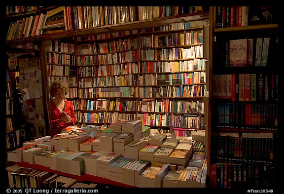 Checking a book in Shakespeare and Company bookstore. Quartier Latin, Paris, France